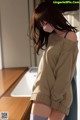 A woman standing in front of a sink in a kitchen.