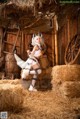 A woman dressed as a fox sitting on a pile of hay.